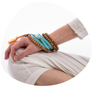 En hand vilar på ett knä i handpositionen Yoga mudra